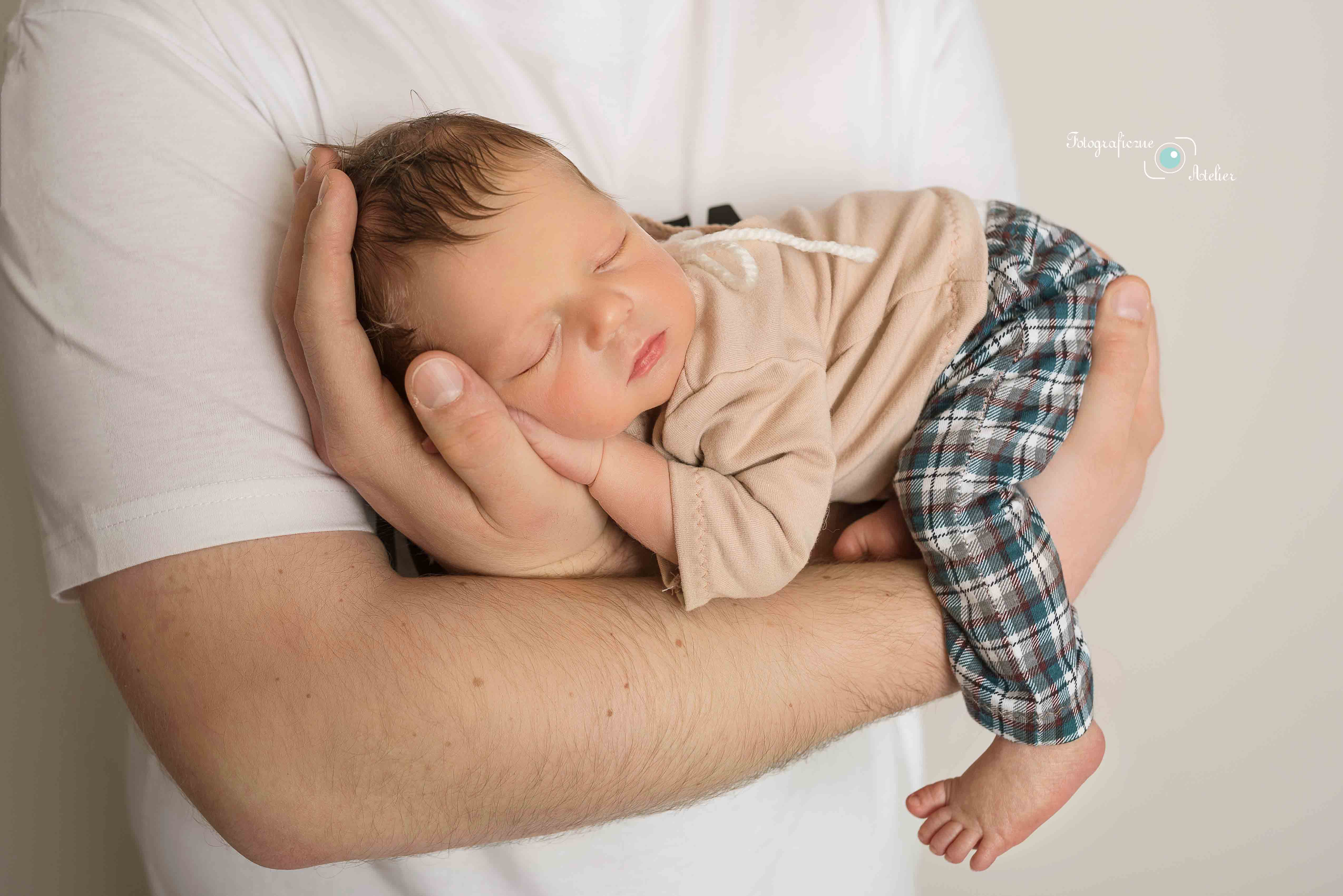 śpiący noworodek u taty Poznań sesja fotograficzna